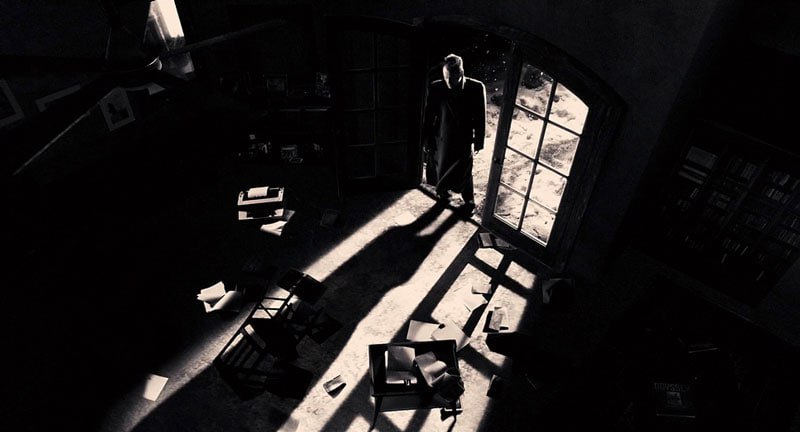 Фігура в пальто біля вікна